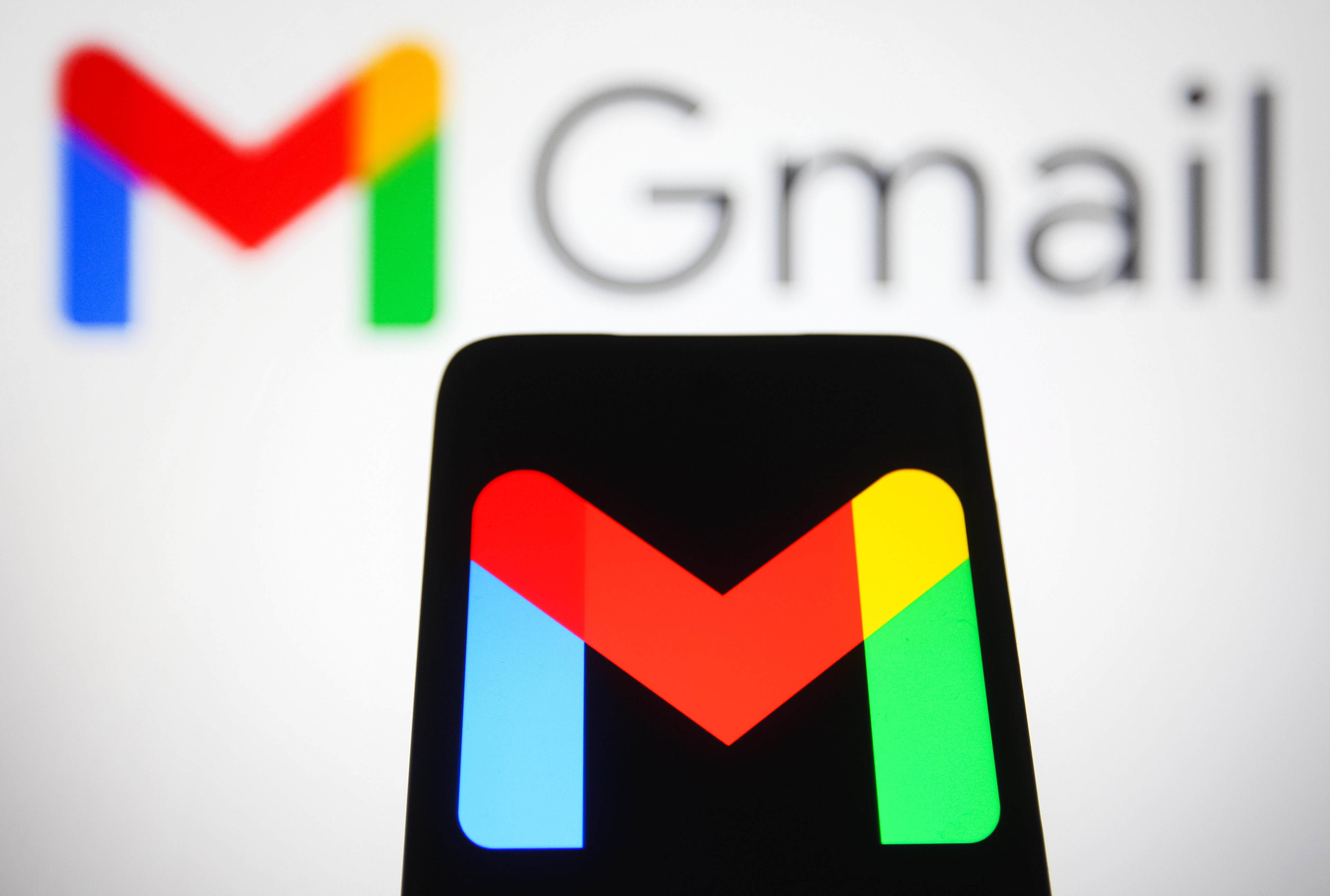 Gmail logo displayed on a smartphone and in the background