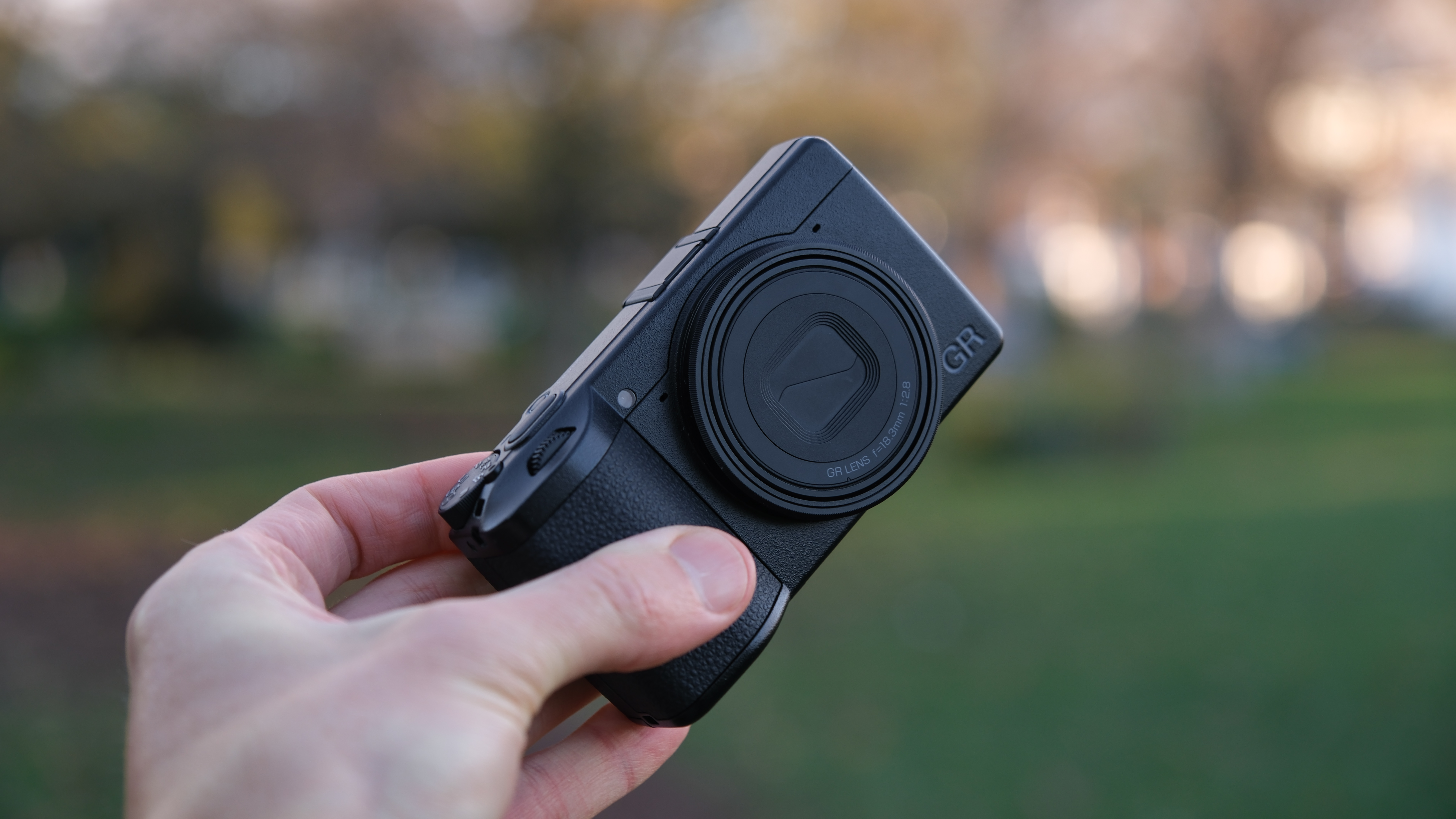 Ricoh GR IV compact camera held in a hand