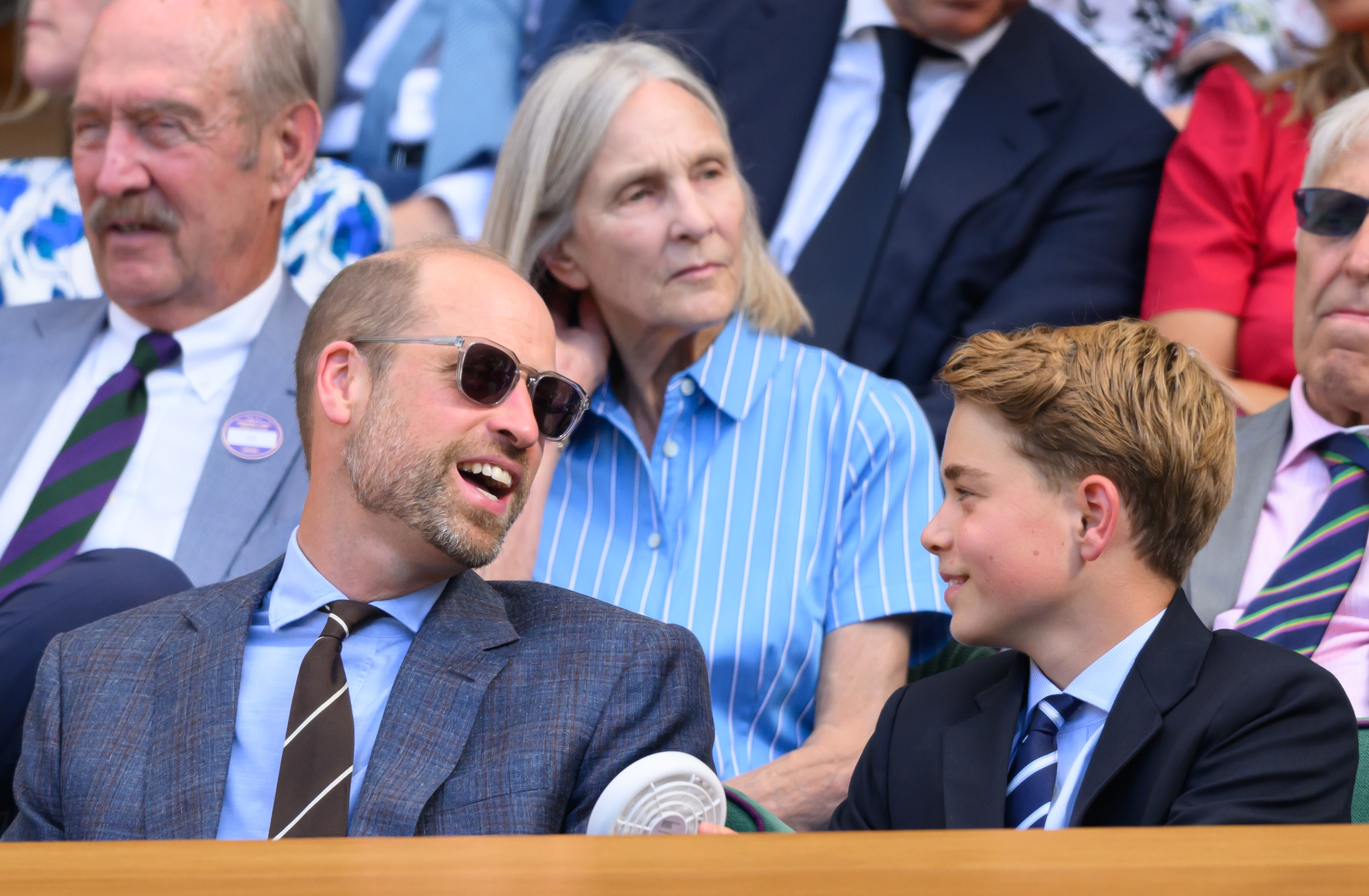 Prince William laughing talking to Prince George at Wimbledon