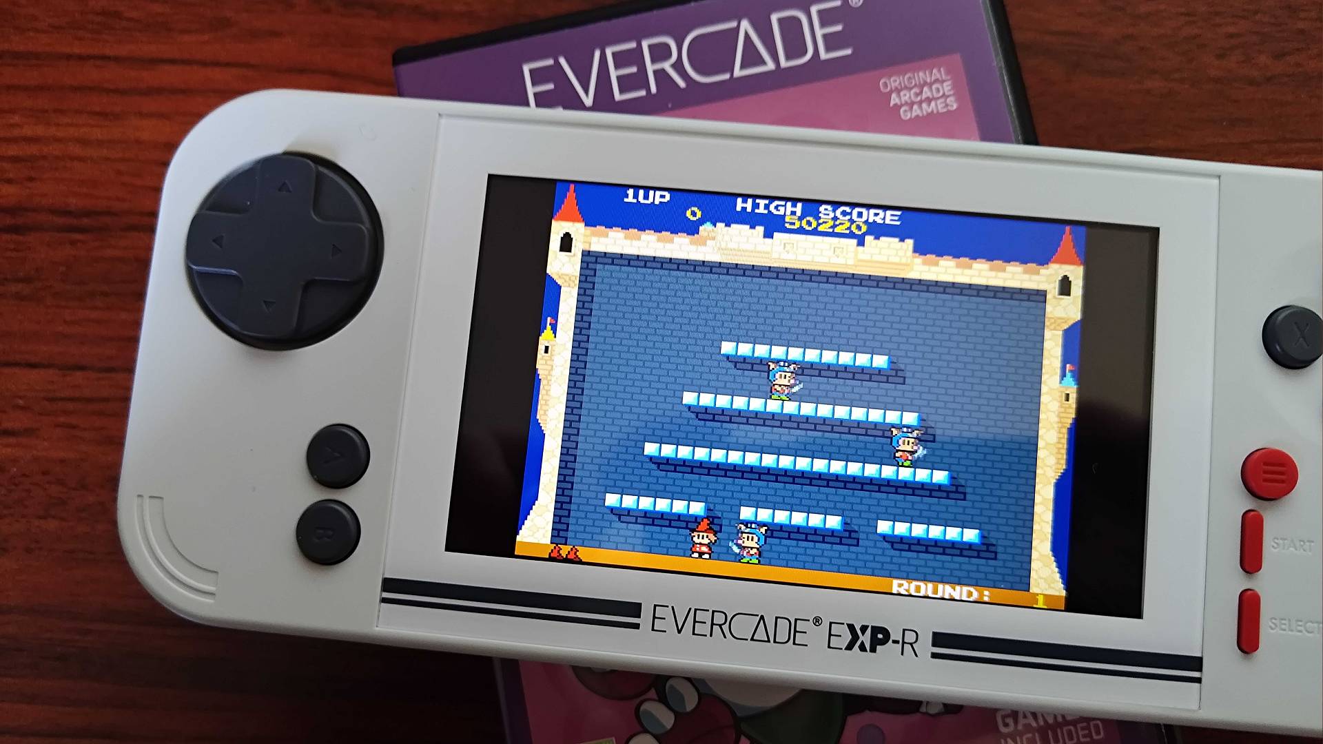 Evercade EXP sitting on Taito Arcade 3 box with The Fairyland Story gameplay on screen.