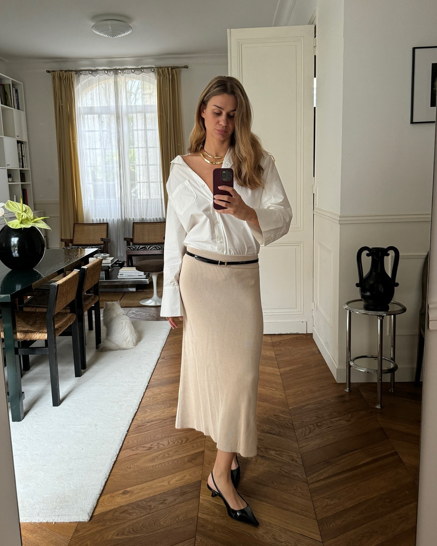 Influencer Anne wears a beige skirt and white button down.