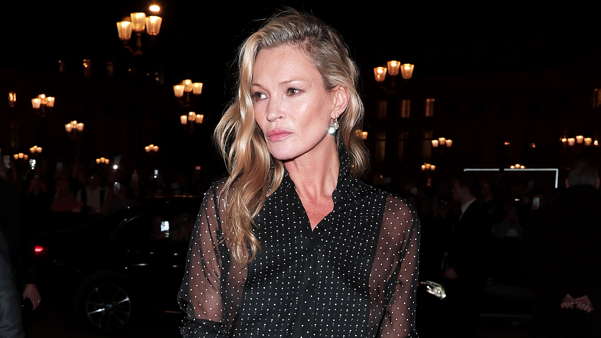 Kate Moss wearing a sheer polka dot blouse during Paris Fashion Week