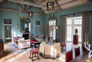 Turquoise rustic living room with fireplace and dining table