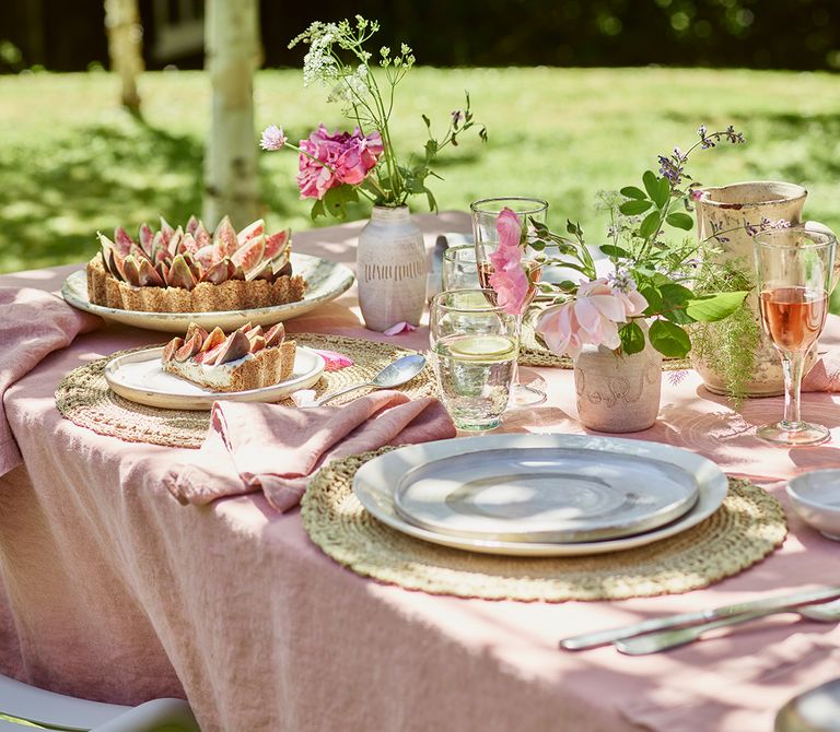 outdoor table with pink tablecloth and fig tart