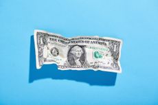 crumpled US dollar bill on blue background