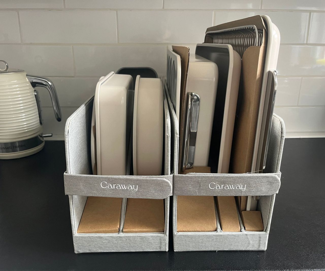 A collection of cream and grey bakeware on a black kitchen counter