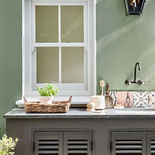outdoor sink with grey cabinet and plant