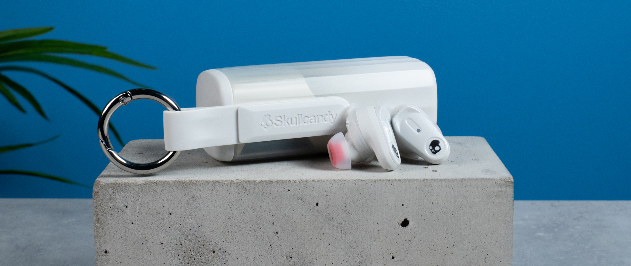 the skullcandy x bose method 360 anc earbuds in white, with a long charging case, a carabiner clip, and various silicone tip sizes