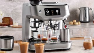 Breville Oracle Dual Boiler coffee maker on kitchen counter with drinks