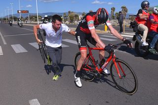 A mechanic tries to get Rohan Dennis back to racing after a late crash on stage 3 of the Giro d'Italia.