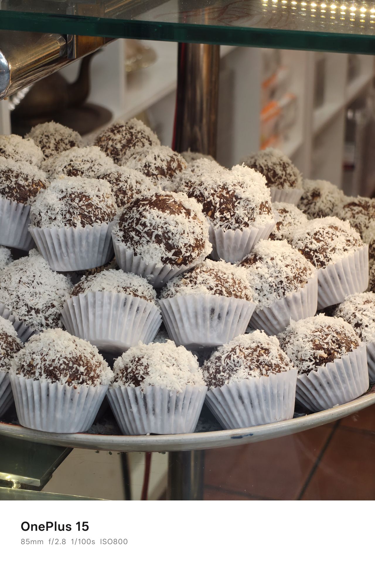 Cupcakes with frosting piled up on a plate in a store window