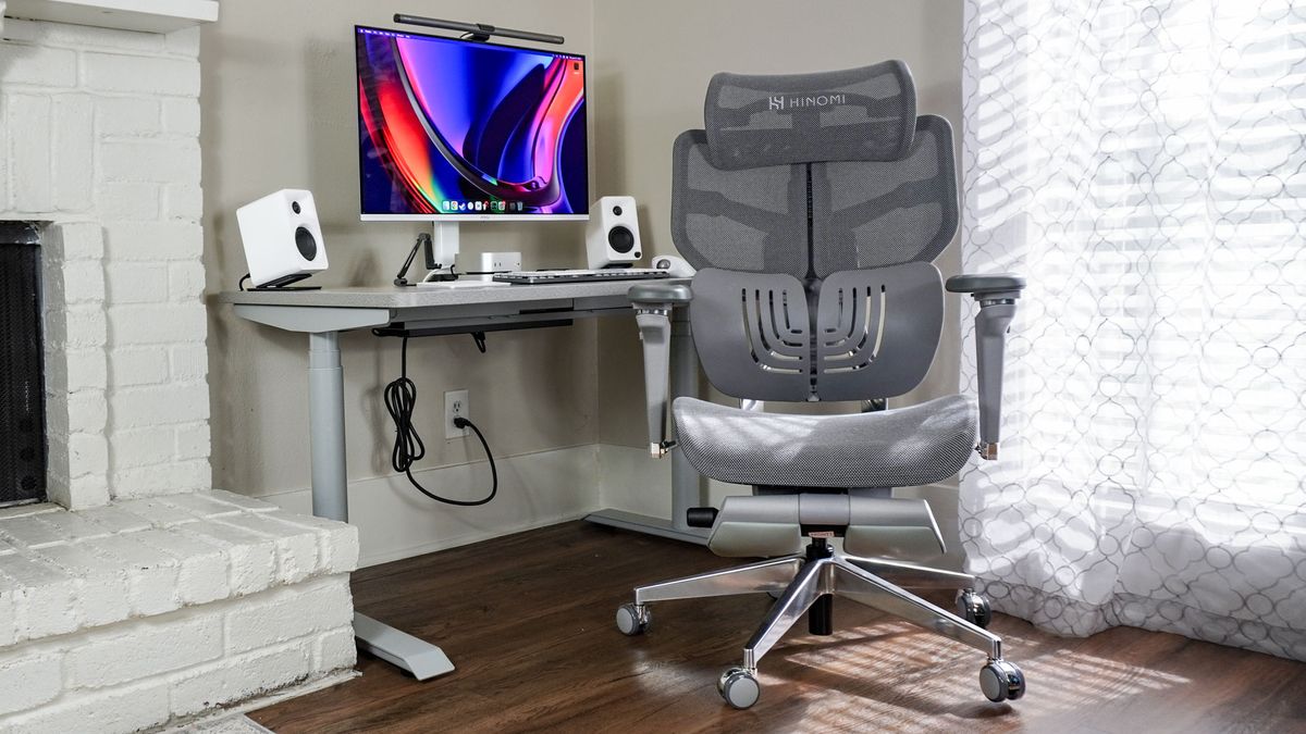 The Hinomi X1 ergonomic office chair in front of a desk setup next to a fire place