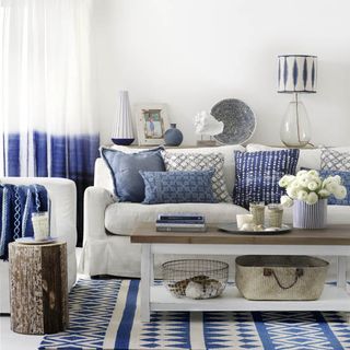 blue and white living room with white wall and pillows on sofa