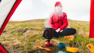 best freeze-dried meals: hiker boiling water on a stove