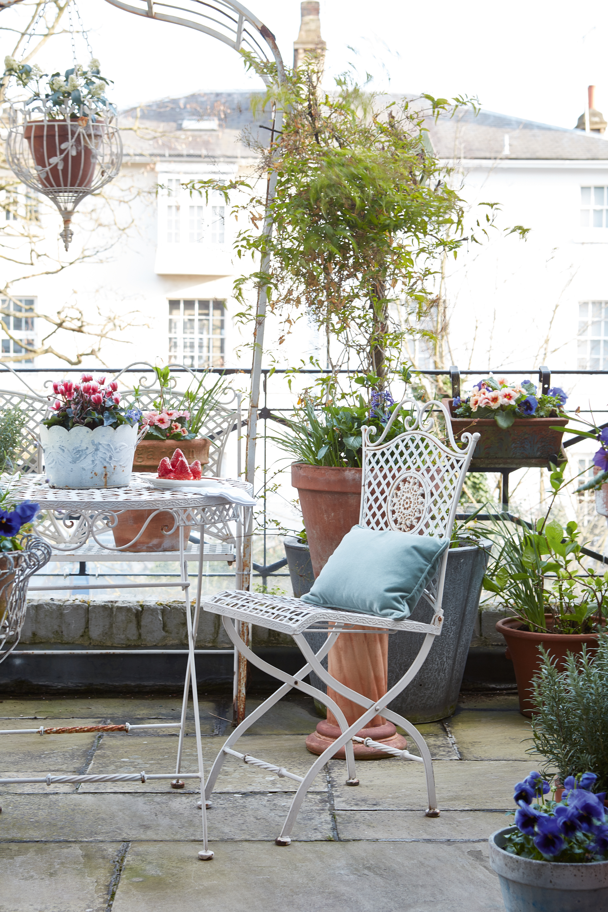 balcony in city apartment with plants garden table and chairs