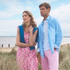 Couple wearing Crew Clothing outfits stood by the beach 