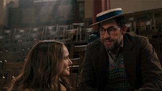 Natalie Portman on the left looking at John Krasinski, who is wearing a straw hat, on the right. 
