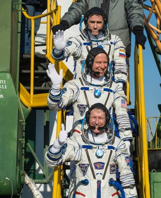 Russian cosmonaut Yuri Malenchenko (top), NASA astronaut Tim Kopra (center) and British astronaut Tim Peake of the European Space Agency wave farewell as they board their Soyuz rocket for a launch to the International Space Station on Dec. 15, 2015 at Baikonur Cosmodrome in Kazakhstan. The trio launched on a six-month mission to the station.