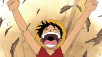 Luffy smiling and breaking apart some wooden floor boards during the anime One Piece. 