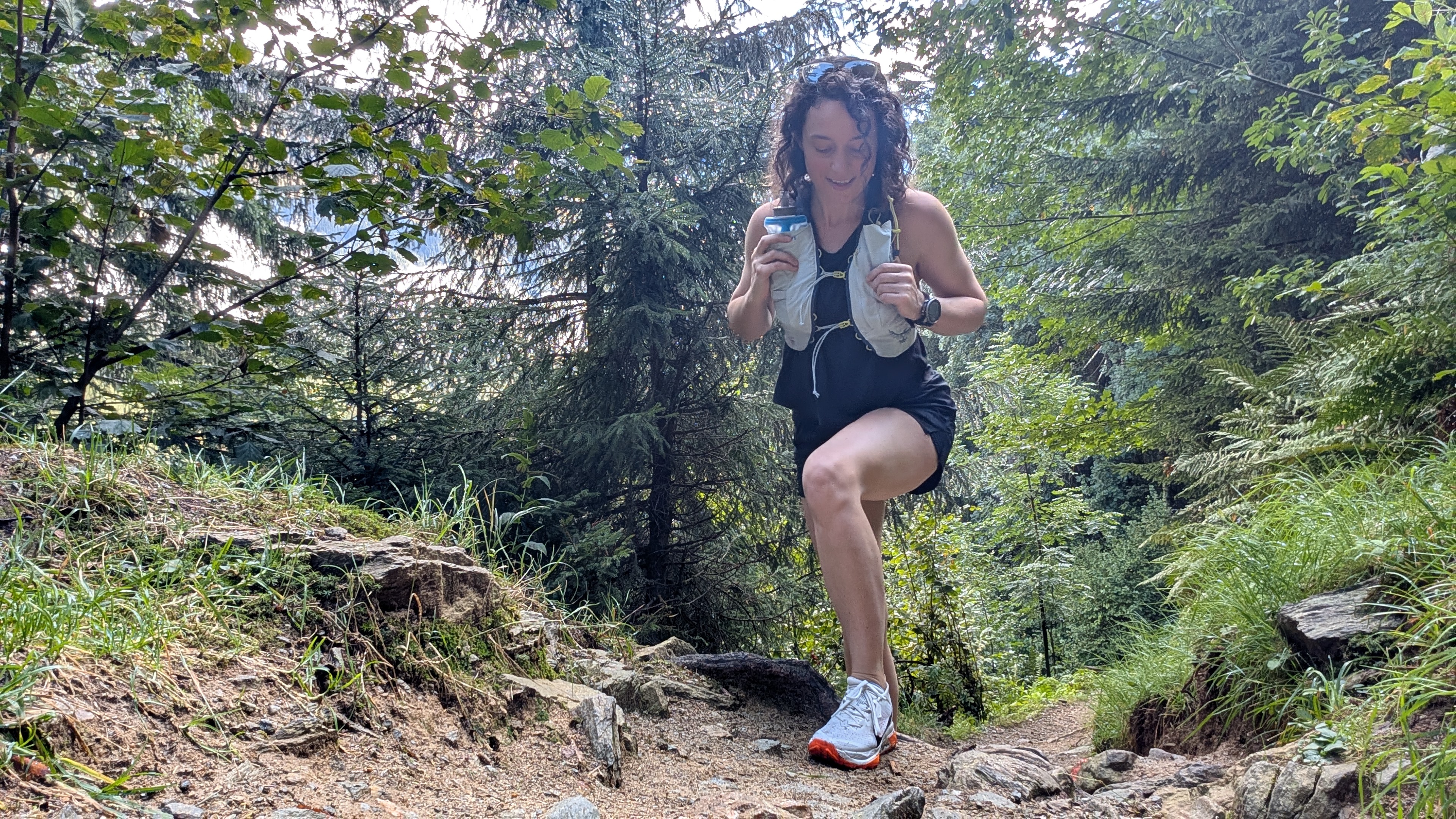 A woman hiking in the Alps wearing a hydration vest