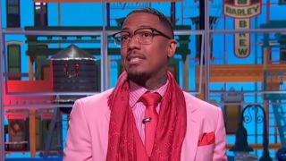 Nick Cannon wearing pink suit and tie on his talk show