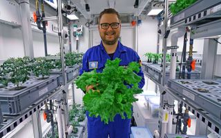 Paul Zabel holds veggies grown in the EDEN ISS greenhouse in Antarctica.