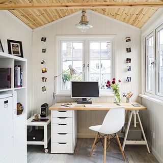 home office with office table near window and white chair