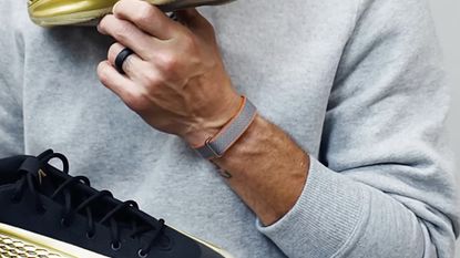 Basketball player Steph Curry wearing an unreleased screenless Fitbit wearable.