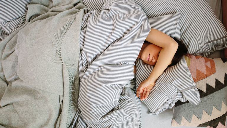 Buying a mattress online: girl sleeping in bed by getty images