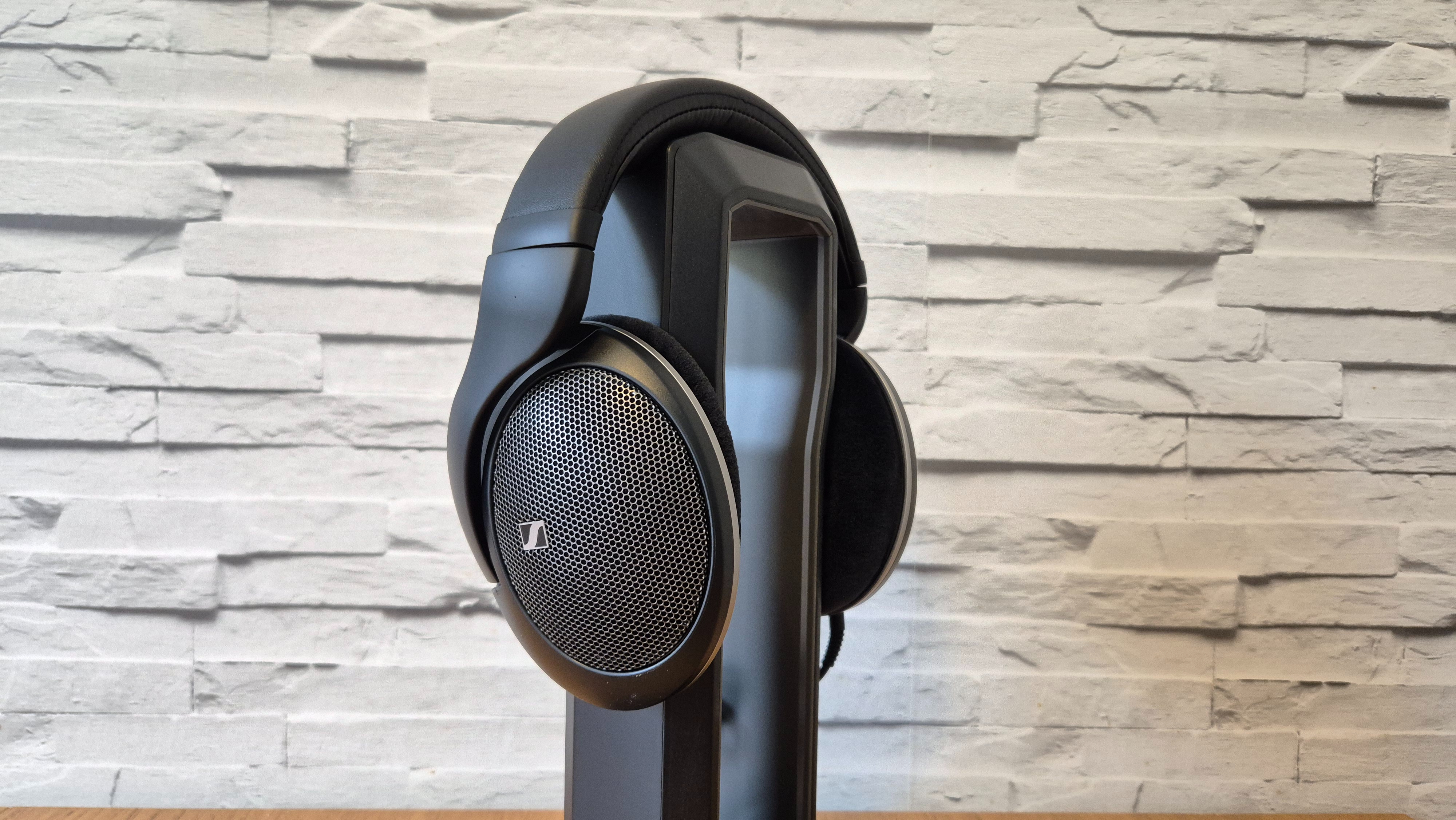 The Sennheiser HD 550 headphones on a wooden surface in front of a white brick background