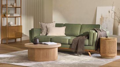 Our experts share ideas on how to style a sofa in a small living room like this beautiful green sofa dressed with cream pillows and a draped dark brown throw blanket