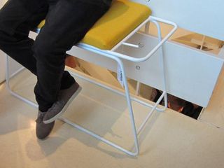 A rectangular white metal framed seat with yellow cushioning