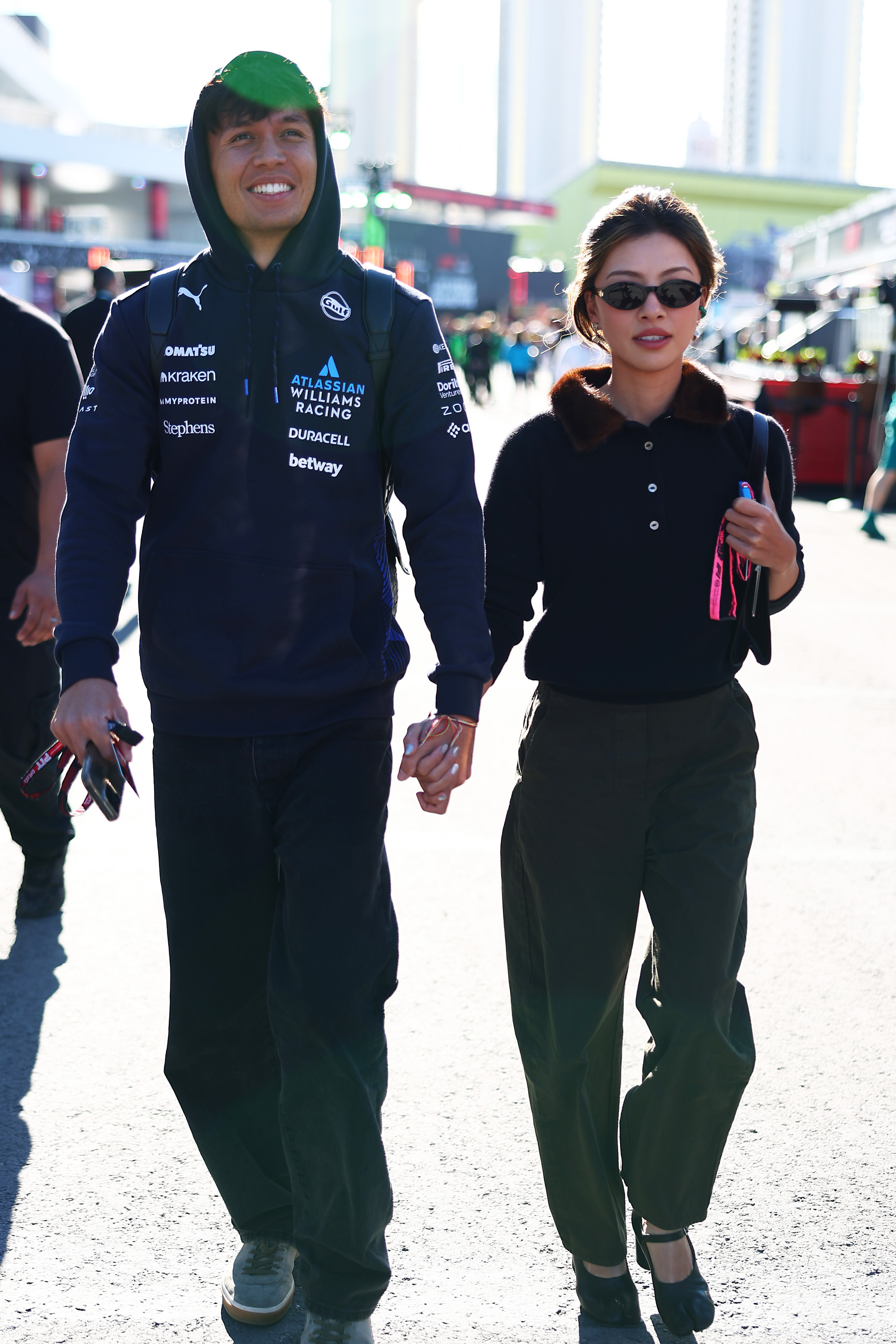 LAS VEGAS, NEVADA - NOVEMBER 20: Alexander Albon of Thailand and Williams and Lily Muni He arrive in the Paddock prior to practice ahead of the F1 Grand Prix of Las Vegas at Las Vegas Strip Circuit on November 20, 2025 in Las Vegas, Nevada.