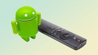 An Android figurine next to a TV remote