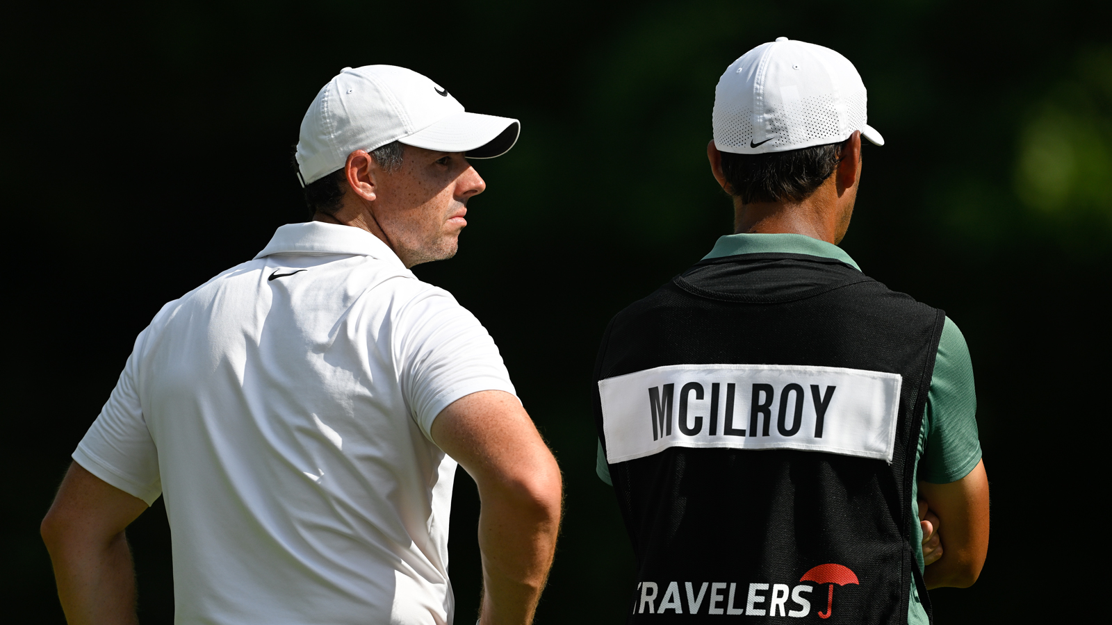 Rory McIlroy and his caddie look up to the sky