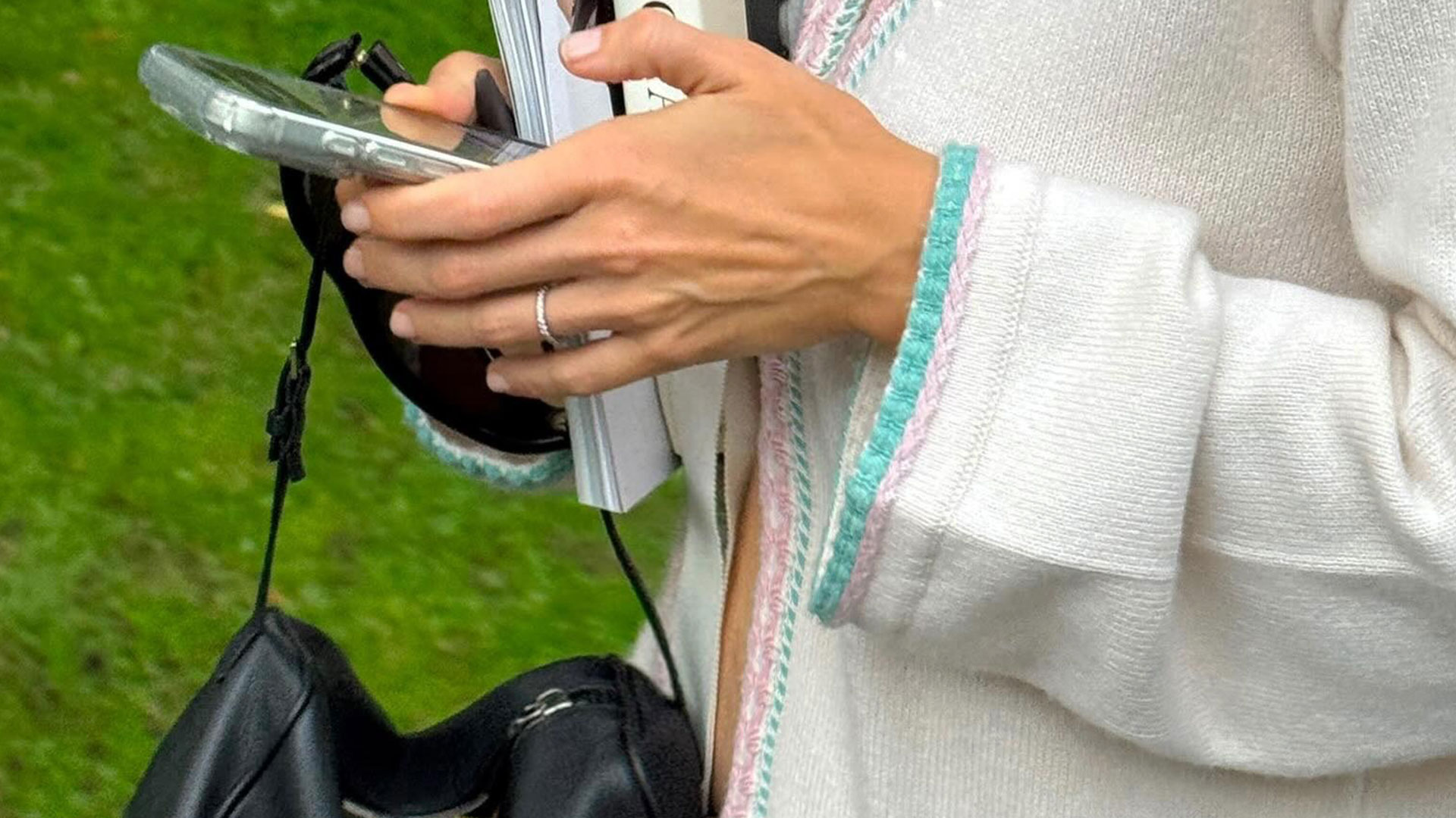 @rachelle.rowlings holding cell phone wearing Chanel cardigan and The Row 90s Bag.