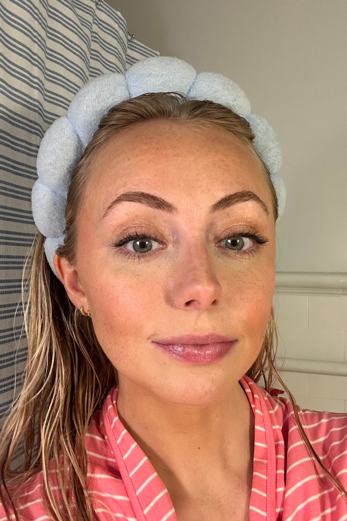 Emery Doney after using the Maybelline Fit Me Matte + Poreless Liquid Foundation with a blue headband and pink robe
