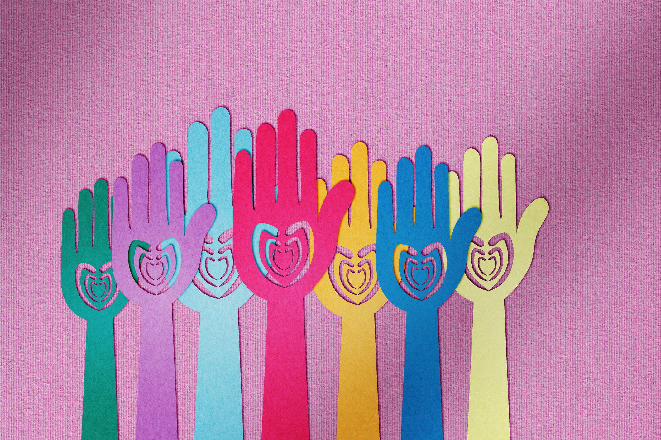 Cut-outs of hands with hearts on them on different colors of paper.