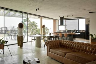Living room with floor to ceiling glazing to outdoors at Casa Prática, by Estúdio Zargos