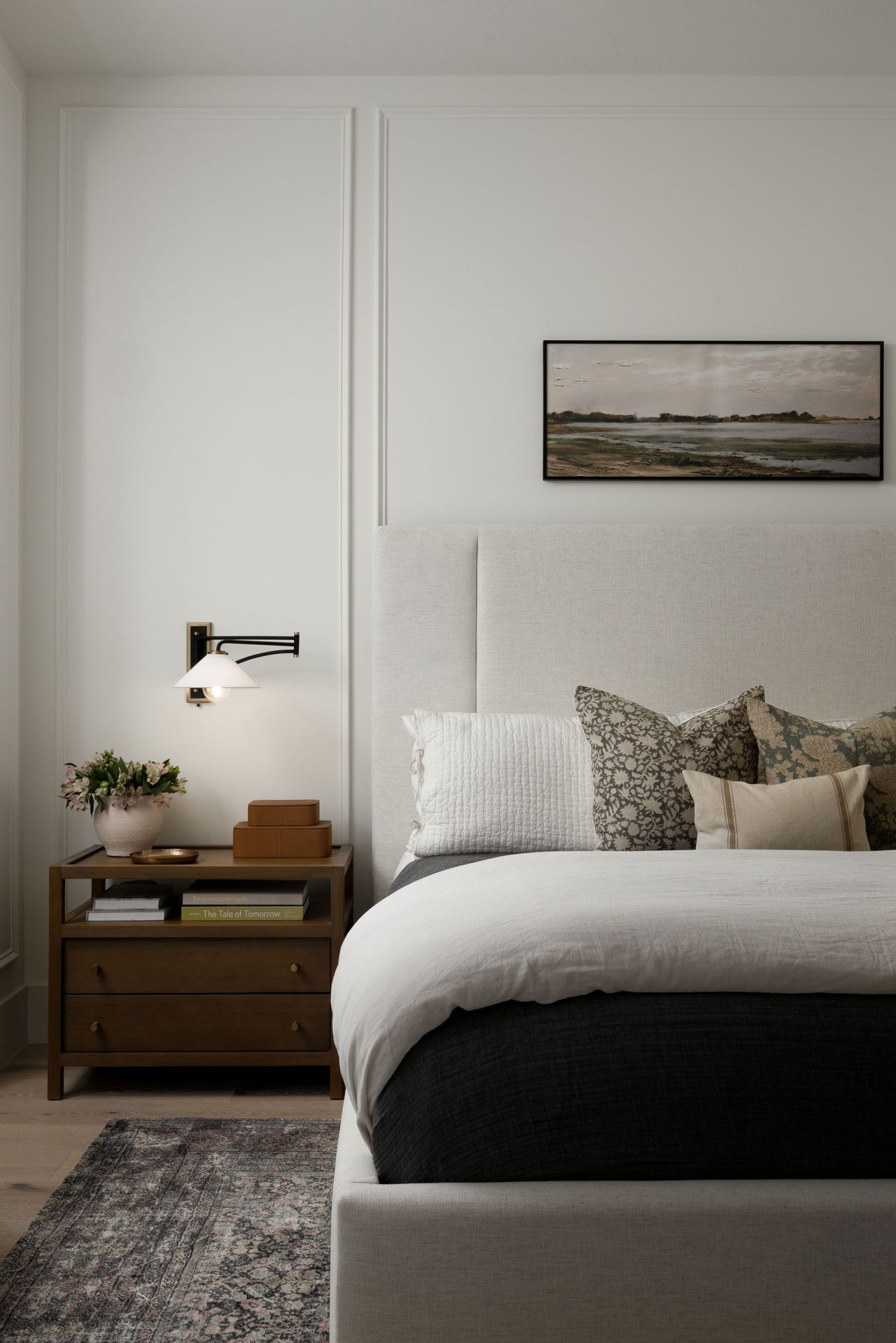 a neutral bedroom with a wood nightstand