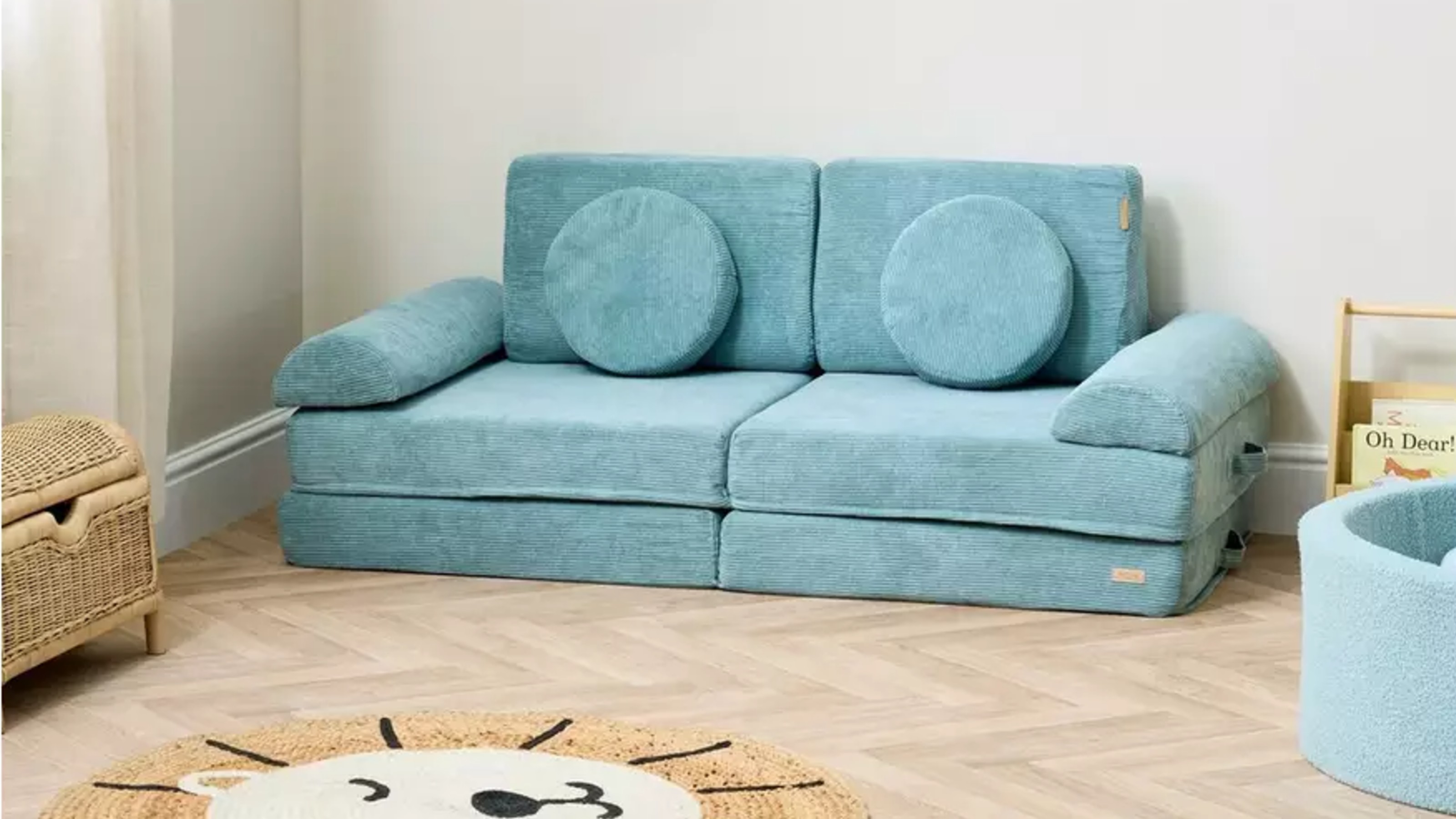 Tutti Bambini Montessori Kids Play Sofa in Ocean Stone in a kids' room with a lion head-shaped rug