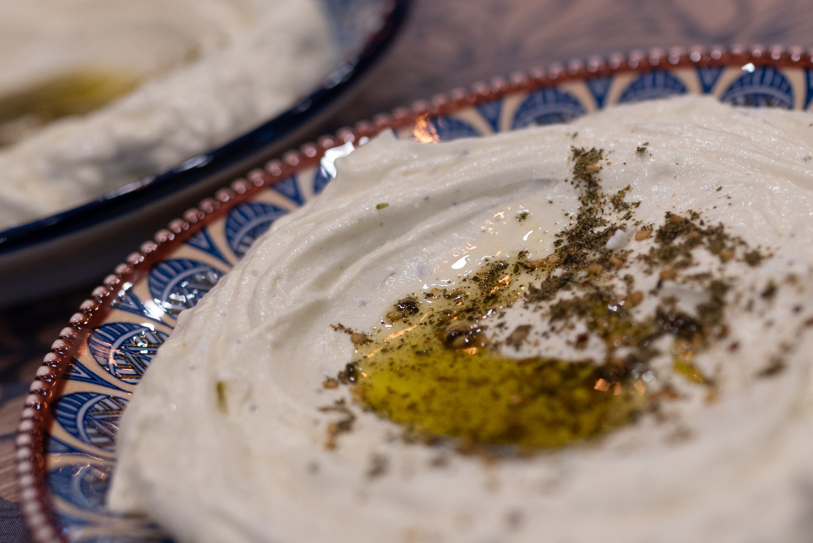 A plate of homemade hummus on a patterned plate.