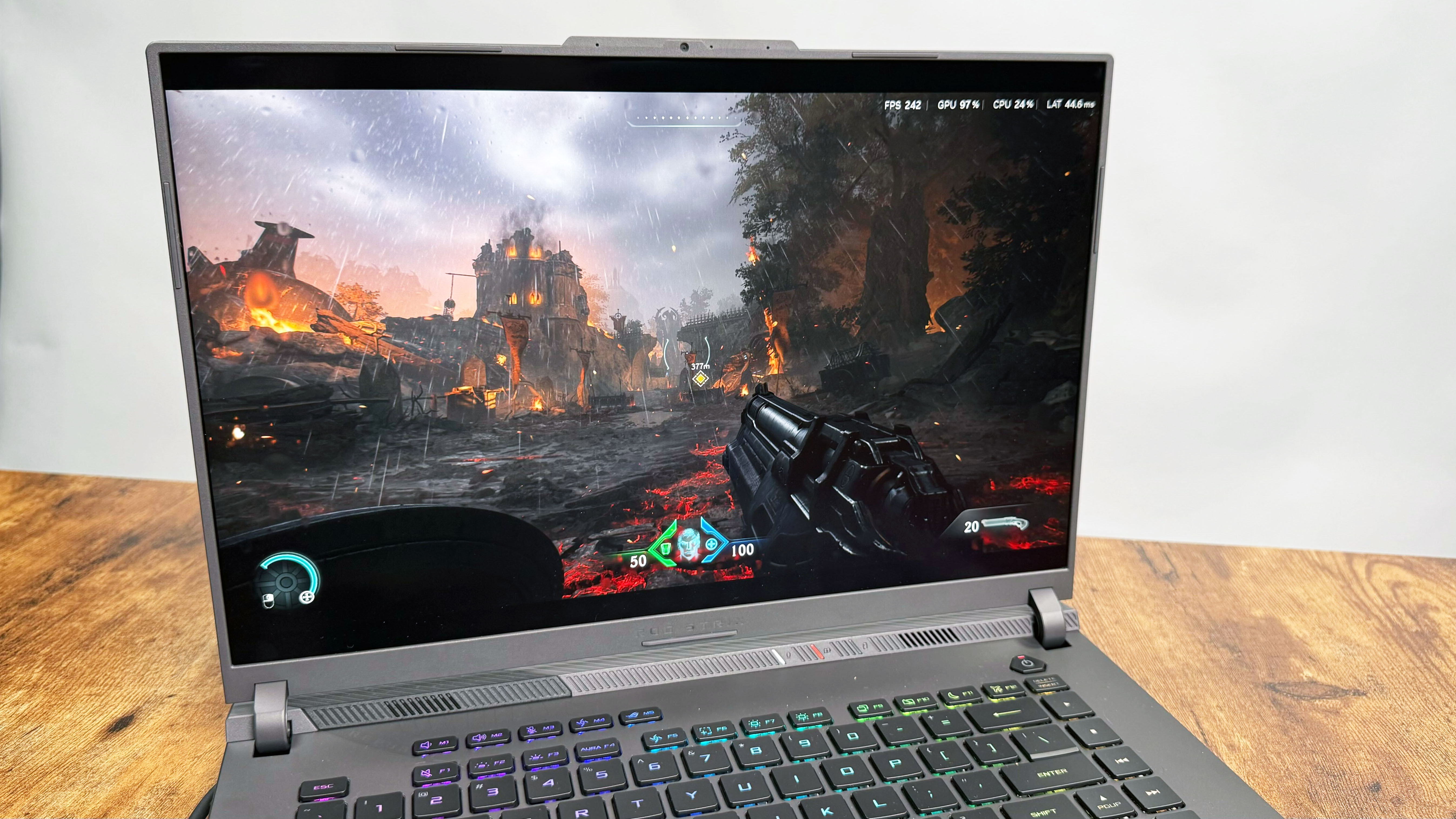Asus ROG Strix G16 (G614FR) gaming laptop on a wooden desk against a gray background.
