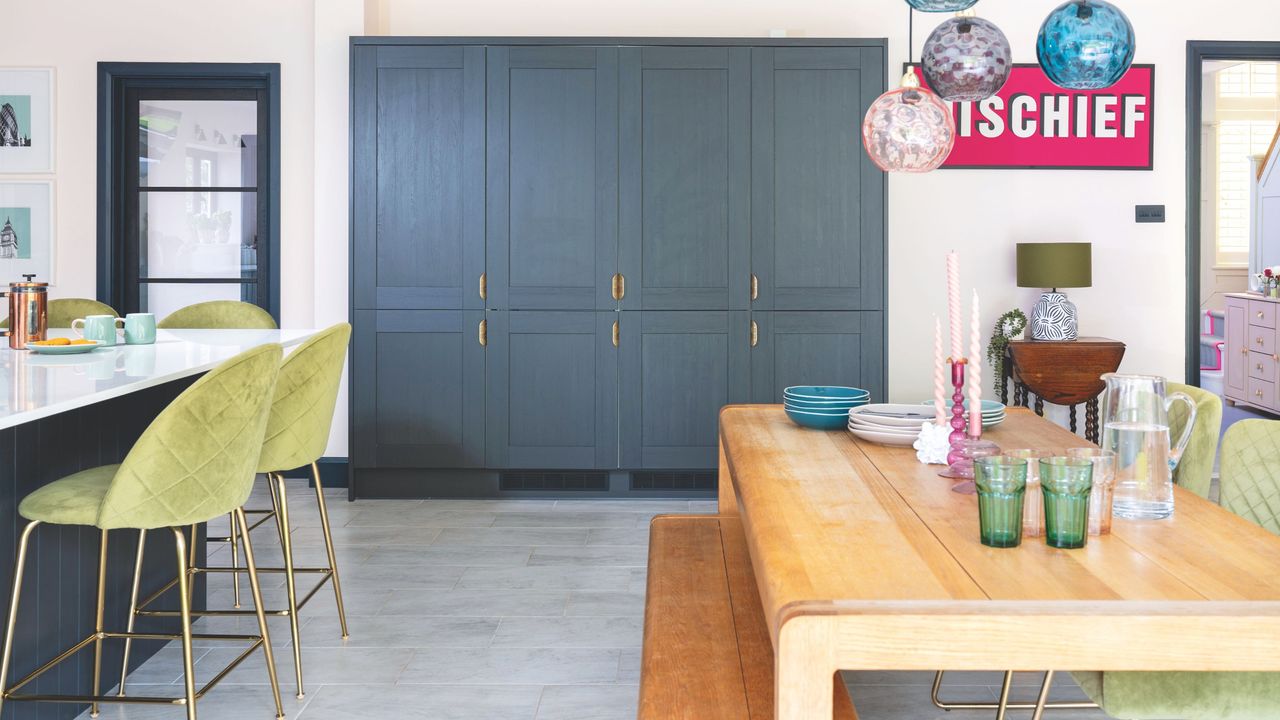 Open-plan kitchen and dining area with a wooden dining table, blue kitchen cabinetry and a breakfast island