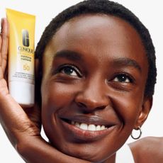 Woman holding Clinique UV Sunscreen