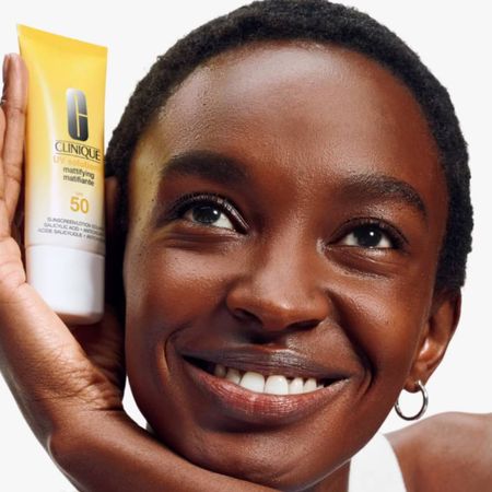 Woman holding Clinique UV Sunscreen