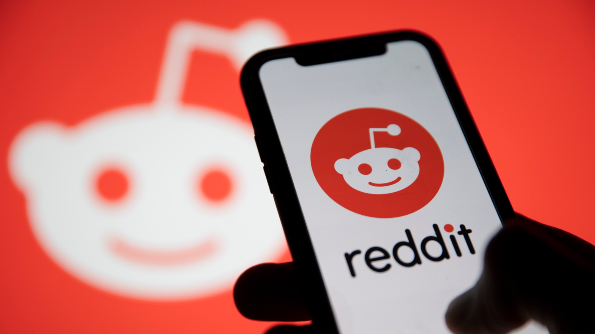 Логотип Reddit и логотип Reddit на телефоне