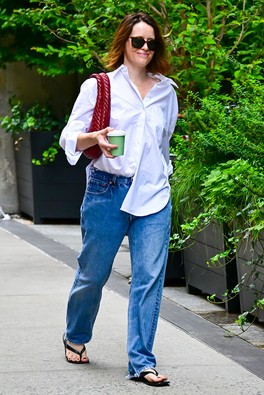 Claire Foy wearing a white button-down, blue jeans, and flip flops