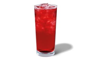 A tall glass of Starbucks Hibiscus Iced Tea red in colour