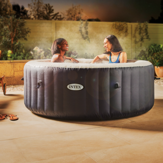 Aldi spa pool on a garden patio with two women enjoying it.